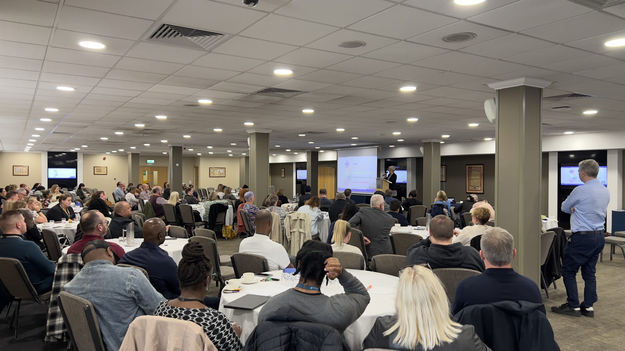 A presentation in front of a room full of staff